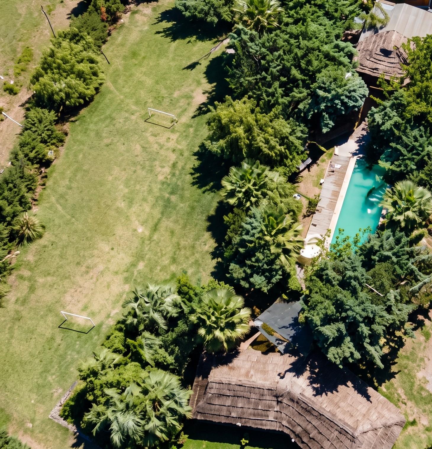 Vista aérea del complejo: parque arbolado, pileta, quincho y cancha de fútbol
