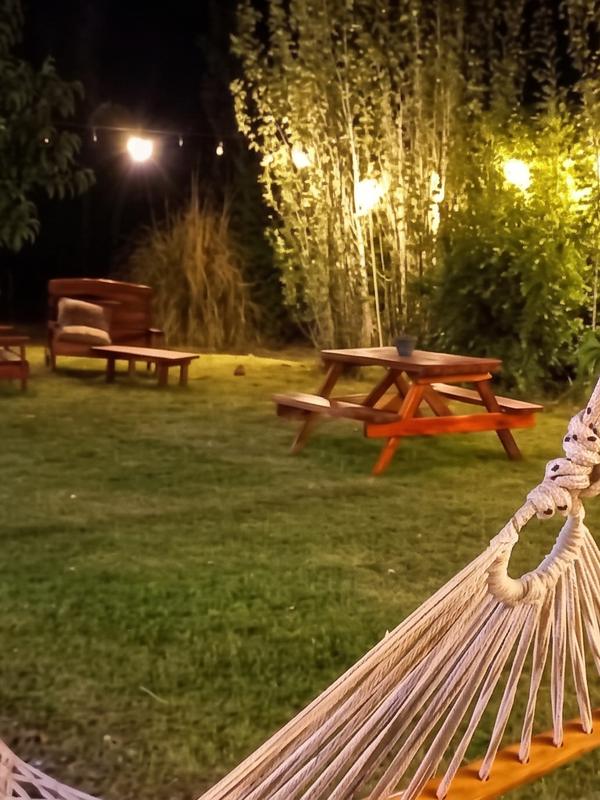 Hamaca paraguaya y mesas de picnic en el parque iluminado de noche