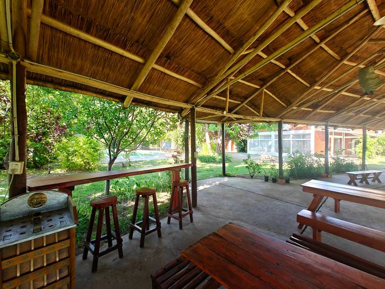 Barra con banquetas y juego del sapo bajo el quincho