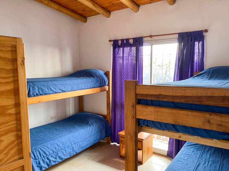 Dormitorio con dos cuchetas de madera y ventana