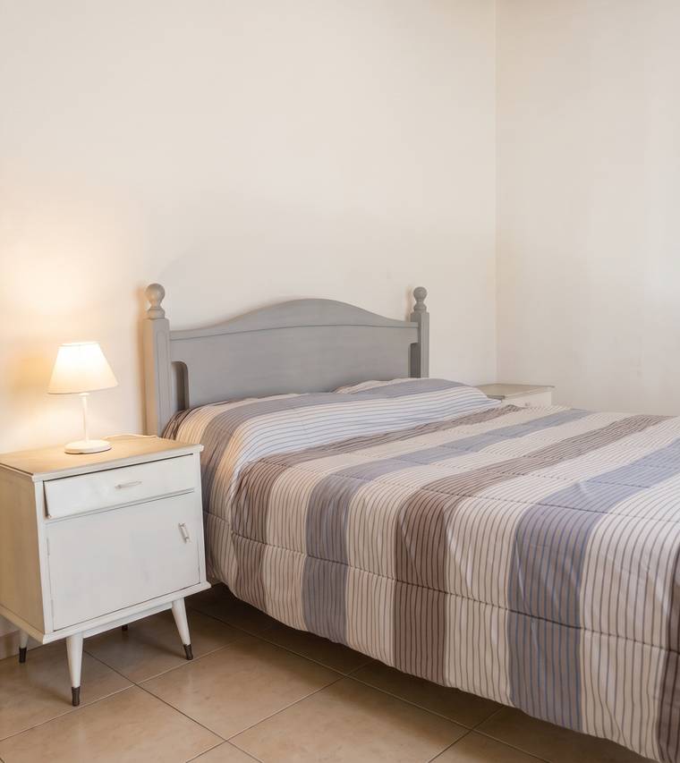 Dormitorio con cama doble y mesa de luz