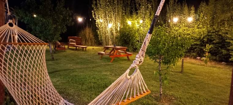 Hamaca y mesas de picnic bajo luces de noche